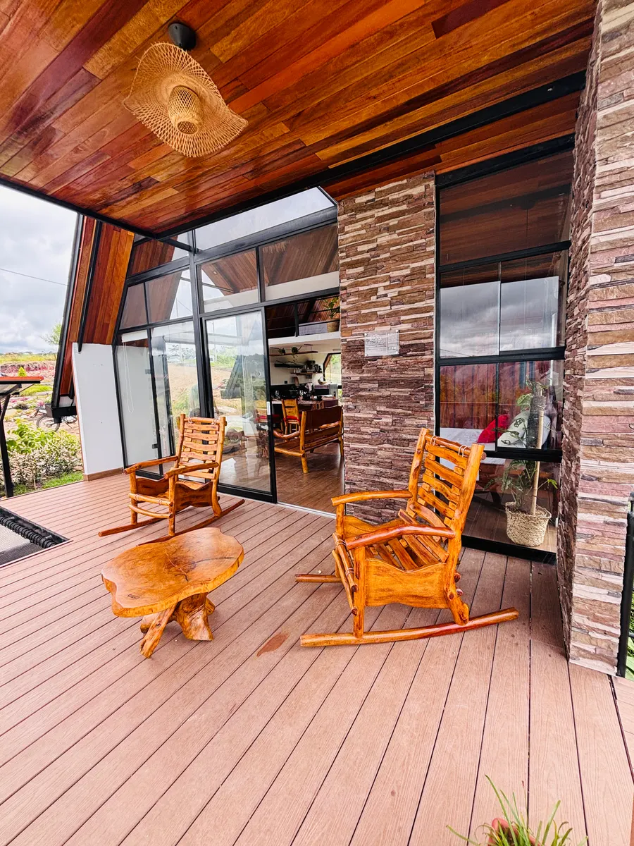 Terraza con mamparas de aluminio y vidrio y muebles de madera