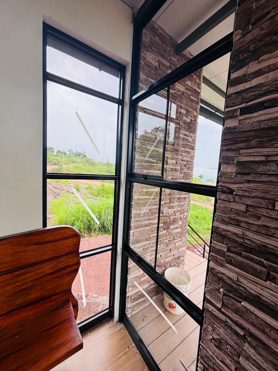 Ventanas de aluminio negro en esquina con vista al campo